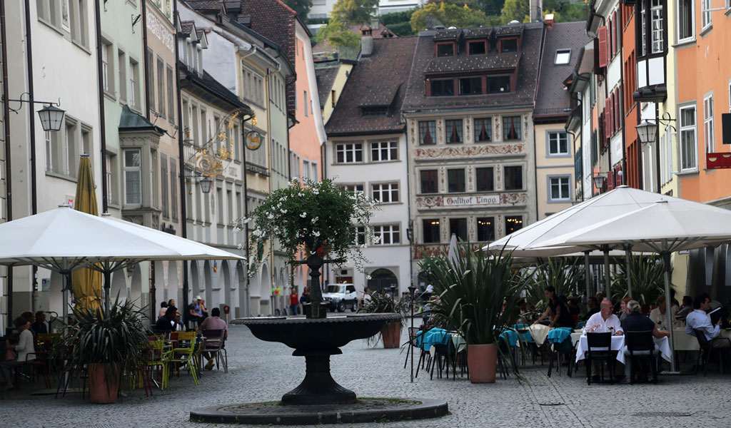 Altstadt von Feldkirch mit den historischen Gebäuden, einem Brunnen mittig und Gastgarten