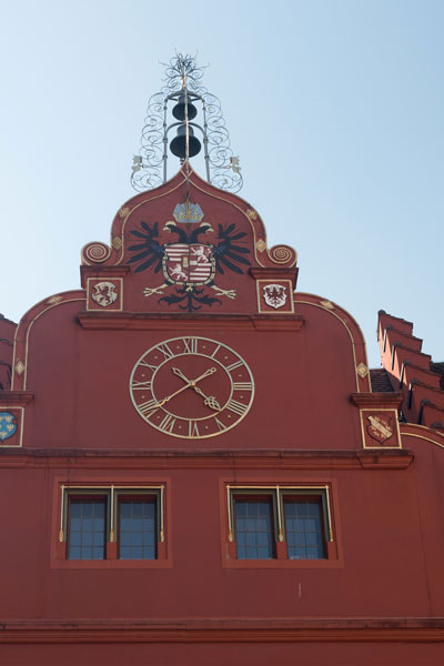 Detailansicht Goldene Turmuhr des alten Rathauses mit roter Fassade
