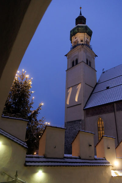 Blick auf die beleuchtete Pfarrkirche Sankt Nikolaus bei Nacht